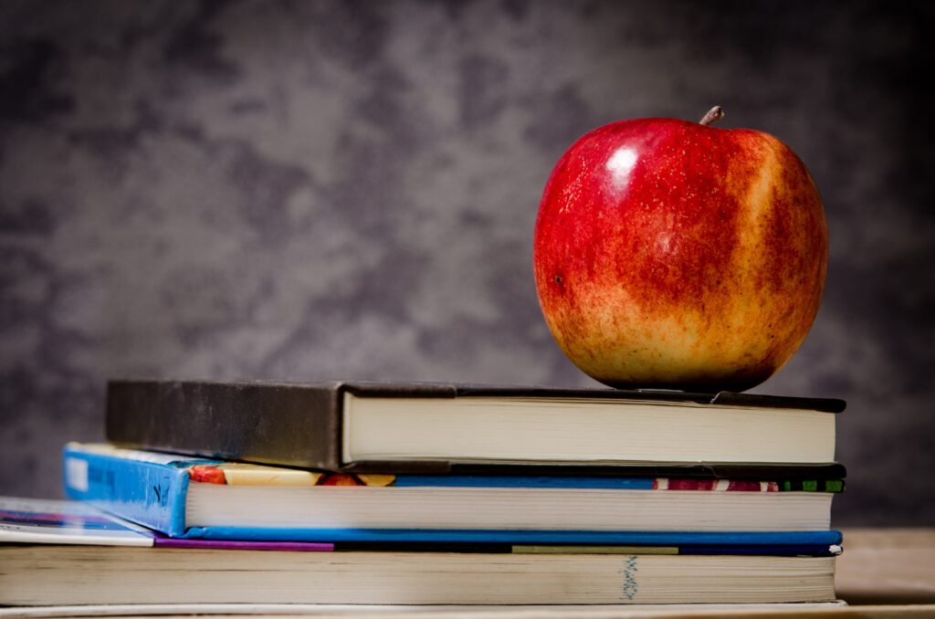 Apple sitting on school books. Placeholder image for all schools and add a school listing form.