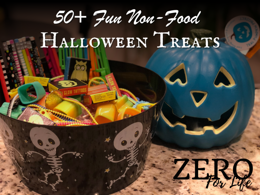 50+ Fun Non-Food Halloween Treats. Image of bucket of Halloween party favors and toys next to teal-colored jack-o-lantern.