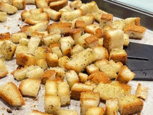 Image of croutons on a pan midway through baking for recipe: Easy Baked Gluten-Free Croutons