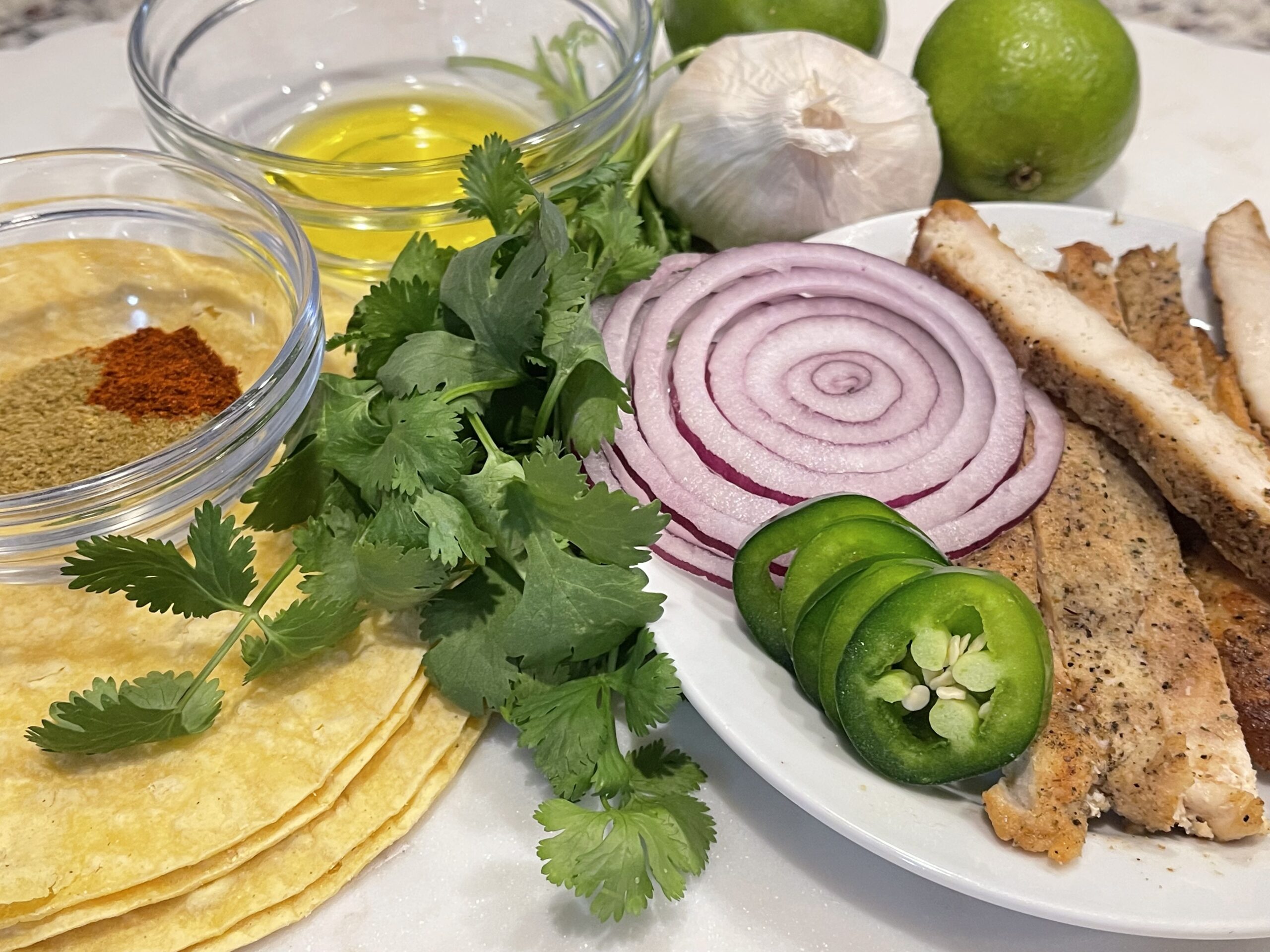 Image of ingredients for 15 Minute Street Tacos including chicken, onions, cilantro, seasonings, and jalapeños.