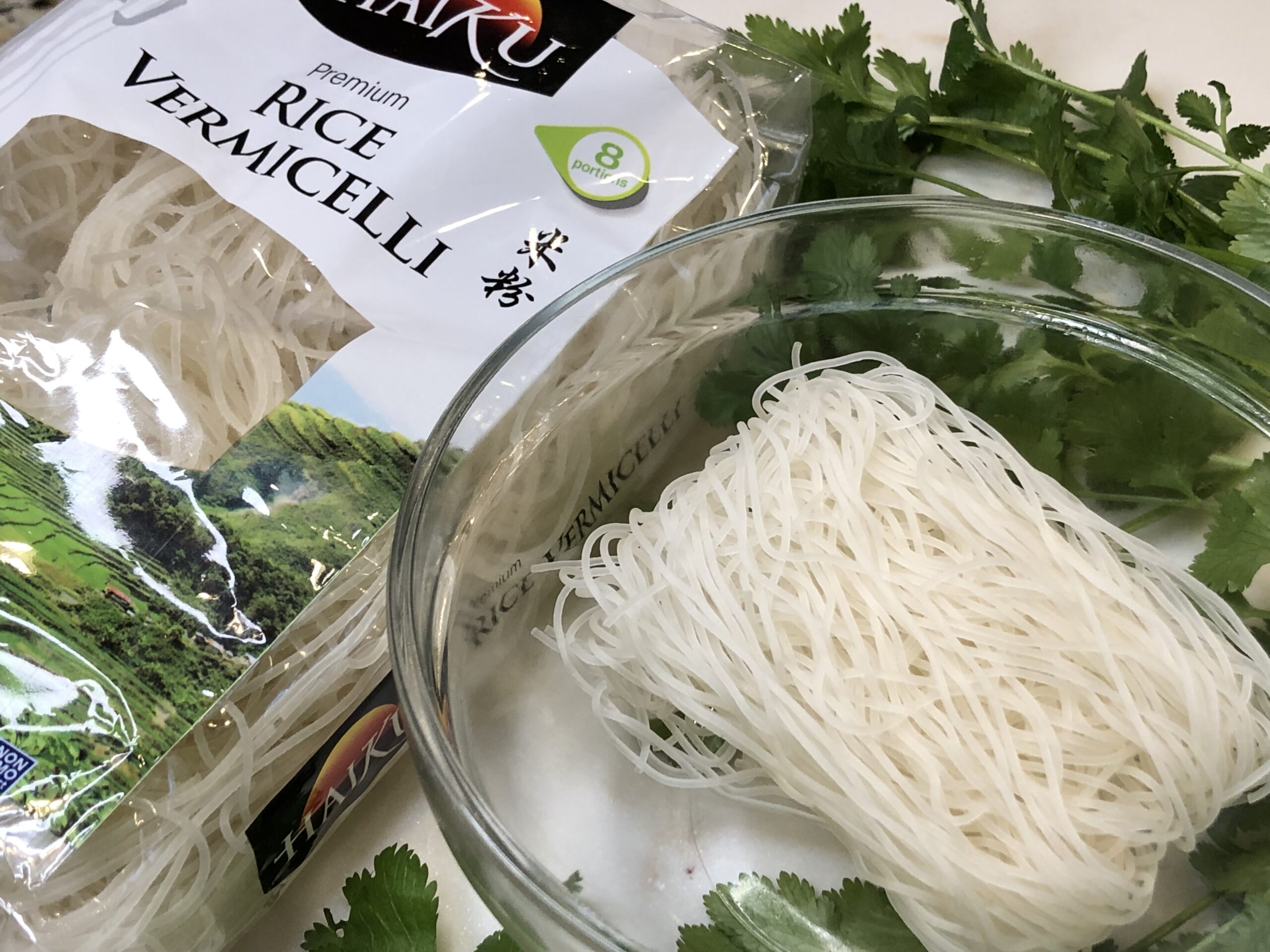 Image of uncooked rice noodles in a bowl that was used in Fast Chicken Pho.